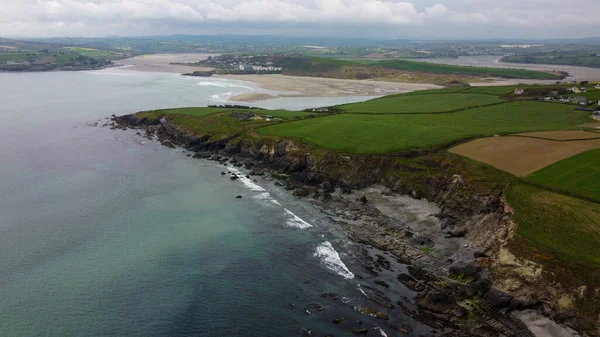 stock image Stone cliffs on the south coast of Ireland, County Cork. Beautiful seaside landscape, top view. Farm fields on the hills. Patchwork landscape. Aerial photo.