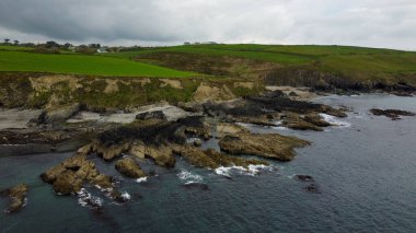 Atlantik kıyısındaki yeşil tepeler, Kuzey Avrupa 'nın doğası. Rocky sahil şeridi. Bulutlu bir günde deniz manzarası. Bulutlu hava, kasvetli gökyüzü.