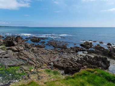 Resimli deniz manzarası. Kaya kıyısı. Açık deniz ve açık mavi gökyüzü.