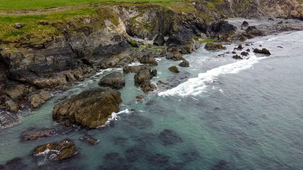 Tidal waves of the Atlantic Ocean near the southern coast of the island of Ireland. Rocky seashore. Seascape, top view. Drone point of view.