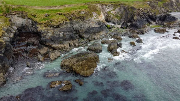 Tidal waves of the Atlantic Ocean near the southern coast of the island of Ireland. Rocky seashore. Seascape, top view. Drone photo.