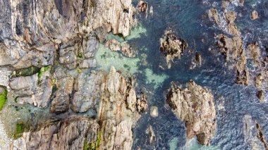 Drone fotoğrafı. Yukarıdan bak. Deniz suyunda bir sürü kaya var, üst manzara. Kuzey Atlantik 'in sahil kayalıkları. Deniz kenarındaki güzel doğa. Kuzey Avrupa 'nın dramatik deniz manzarası.