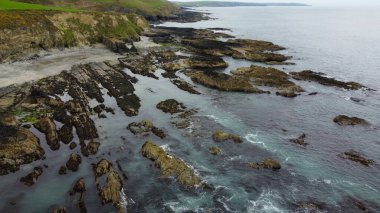 İrlanda 'nın güneyindeki Atlantik Okyanusu' nun parlak kayalık kıyıları. Güzel Kuzey Avrupa doğası. Kayalık kıyı şeridinin havadan görüntüsü. Hava fotoğrafı.