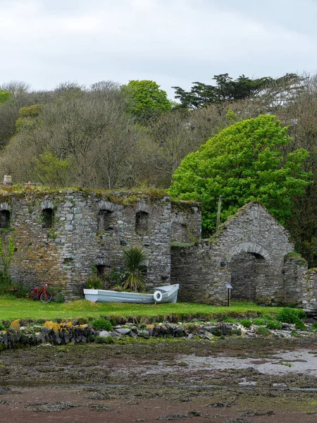 The ruins of Arundel grain store on the shore of Clonakilty Bay in the spring. An old stone building in Ireland, Europe. Historical architectural monument, landscape. Tourist attractions