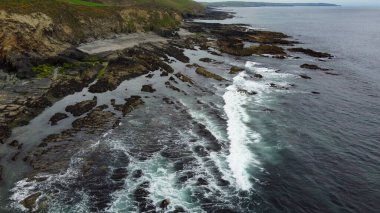 Atlantik Okyanusu 'nun gelgit dalgaları. İrlanda adasının kıyısındaki kayalar. Dalgalarda beyaz deniz köpüğü. Güzel deniz manzarası. Drone bakış açısı.