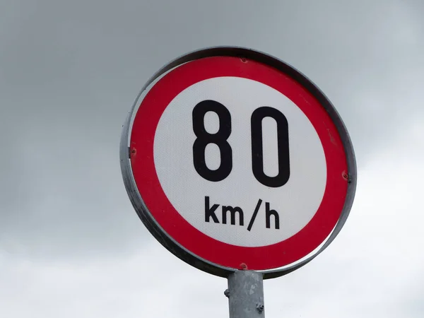 Round sign limiting speed on the background of a cloudy sky. Signs warning of a maximum speed of 80 km h