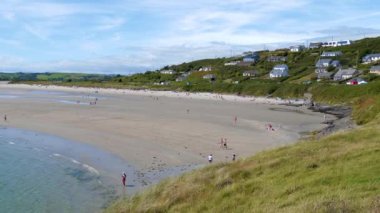 County Cork, İrlanda, 6 Ağustos 2022. Inchydoney plajı yakınlarındaki küçük bir İrlanda köyü. Yazın kumsaldaki insanlar, İrlanda sahil beldesi..