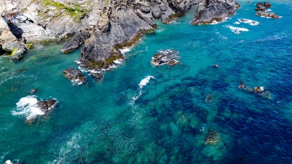 Steep cliffs on the southern coast of Ireland. Turquoise waters of the Atlantic Ocean. Natural beauties of Ireland, West Cork. The rocky coast of the Celtic Sea. Drone photo.