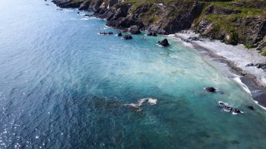Kelt Denizi kıyısında çakıl taşları olan bir sahil, İrlanda 'nın güneyi, üst manzara. Güzel deniz manzarası. Su turkuaz renginde..