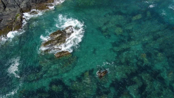 凯尔特海绿松石波中覆盖着黑苔藓的岩石 浪涌上白色的浪花 大西洋水域 — 图库照片