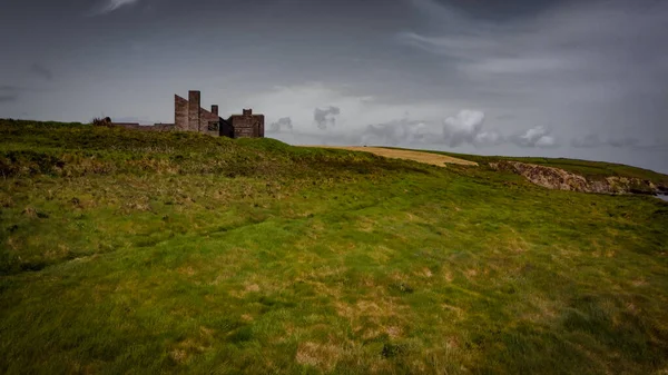 stock image An old unfinished building on a green hill. Beautiful sky with clouds. Drone point of view.