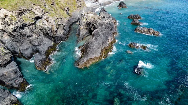 Steep cliffs on the coast of Ireland. Turquoise waters of the Atlantic Ocean. Natural beauties of Ireland, West Cork. The rocky coast of the Celtic Sea. Drone point of view.