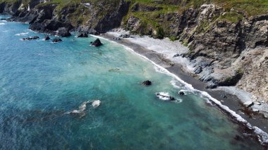 Kelt Denizi kıyısında çakıl taşları olan bir sahil, İrlanda 'nın güneyi, üst manzara. Güzel deniz manzarası. Su turkuaz renginde. Drone bakış açısı.