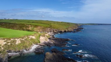 Güneşli bir bahar gününde Atlantik Okyanusu 'ndaki yeşil tepeler. Deniz kıyısında mavi gökyüzü. İrlanda kıyısı, West Cork. Yukarıdan görüntüle.