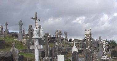 Stone tombstones and Celtic crosses, Catholic cemetery. Overcast cloudy sky over a Christian cemetery in Ireland.