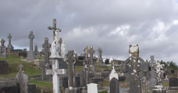石の墓石とケルト人の十字架 カトリックの墓地 アイルランドのキリスト教の墓地の上に曇りの空を曇り — ストック動画