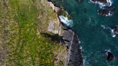 Grassy cliffs on the Atlantic coast. Landscape of Ireland from a height. Seaside rocks. Aerial photo.