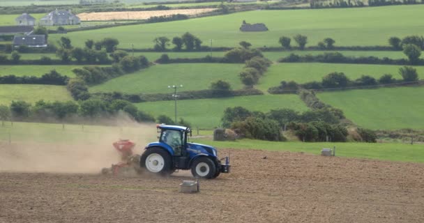 アイルランドのコーク州 2022年8月20日青いトラクターのプロセスと夏に耕起フィールドを播種します 畑での農作業 — ストック動画