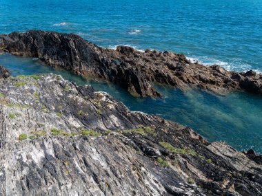 Picturesque cliffs in blue sea water. Seaside landscape. Blue sea beside rock
