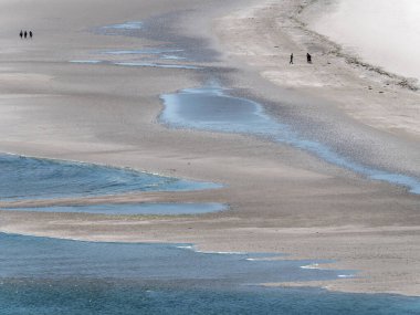 Picturesque beach. A people on a beautiful beach. The famous Irish beach of Inchydoney, a minimalistic landscape. People on beach