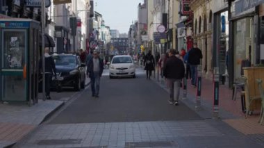 Cork, Ireland, September 30, 2022. The movement of residents along a city street in the center of Cork. Citizens of a European city walk down the street on an autumn morning. video.