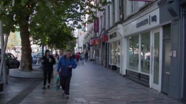 Cork, Ireland, September 30, 2022. The citizens of Cork are walking along the streets of the city on an autumn morning. Urban life in Ireland. People on the street. video.