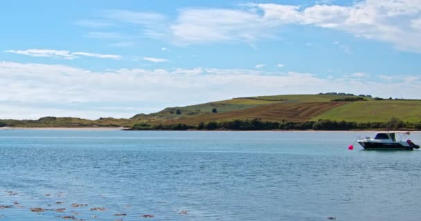 アイルランドのコーク州 2022年8月21日 1隻の小さなモーターボートが晴れた日にClonakilty湾に停泊しています アイルランド沿岸沖の水面に浮かぶボート 海辺の風景 — ストック動画
