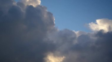 The rapid movement of fluffy cumulus clouds in the blue sky, timelapse video. Cloudy sky as a background.