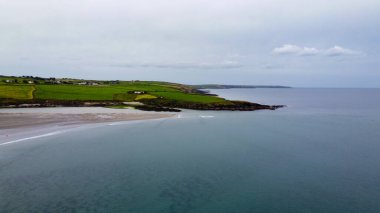 Irish seascape. The coast of the Atlantic Ocean. Green field on island under blue sky