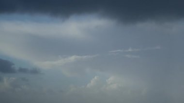 Hızlı hareket eden, kasvetli yağmur bulutlarının, gökyüzündeki kümülüs bulutlarının çarpıcı doğal bir arka plan olarak zamanlanmış videosu..