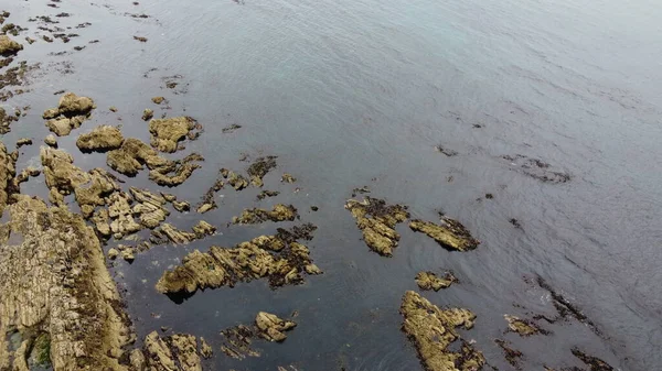 Rocky deniz kıyısı, en üst manzara. Suda büyük kayalar var. Deniz Burnu. Suda kahverengi kaya oluşumu