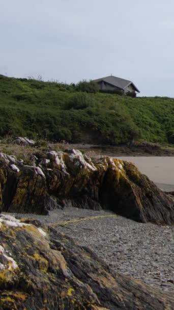 一座田园诗般的爱尔兰风景画 其特色是在茂密的青山顶上的一座小房子和脚下的大石头 垂直录像 — 图库视频影像