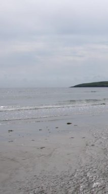 Okyanus dalgaları, yazın ıslak kumlu plaj. Dikey video.