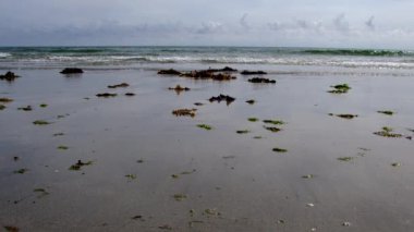 Sakin deniz, kumlu sahil ziyaretçileri dinlenmeye ve manzaranın tadını çıkarmaya davet ediyor..