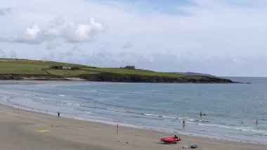 County Cork, İrlanda, 29 Ağustos 2022. Güneşli bir günde, cankurtaranlar için kırmızı lastik bir tekne Inchydoney 'in kumlarında oturur. İrlanda 'da ünlü bir plaj..