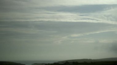 Yeşil tepelerin üzerinde bulutlu İrlanda gökyüzü, zaman ayarlı video. Gökyüzünde hızlı bulutlar uçuşuyor.