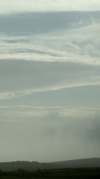 这段逝去的视频展示了爱尔兰绿色山丘上充满活力的戏剧性的天空 当云层在天空中穿行时 它的形状和速度都会发生变化 垂直录像 — 图库视频影像
