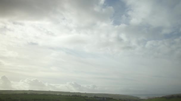 曇りの灰色の雲は アイルランドの緑の領域の上空を速く飛んでいる 加速したタイムラプスビデオ — ストック動画