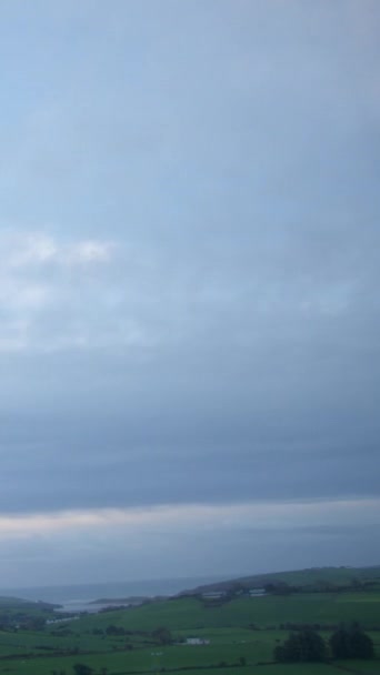 雲はゆっくりとアイルランドの田舎の上空を流れ アイルランドの曇りの朝 時間の経過 垂直ビデオ — ストック動画
