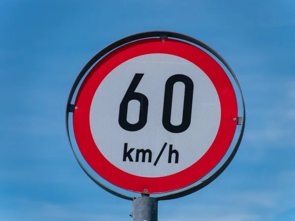 stock image A road sign limiting the speed to 60 km h on a blue sky background.