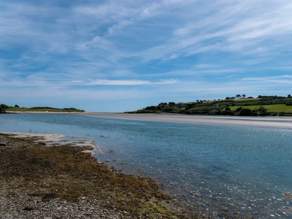 アイルランドの海岸を白い雲が覆う美しい青空 晴れた夏の日に海辺の風景 青い空の下で水の体 — ストック写真
