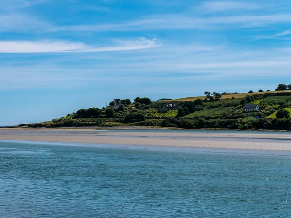 アイルランドの海岸に白い雲がある青い空 晴れた夏の日に海辺の風景 青い空の下で水の体 — ストック写真