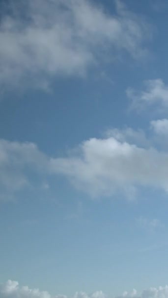 青い空の背景に小さな雲 垂直ビデオ — ストック動画
