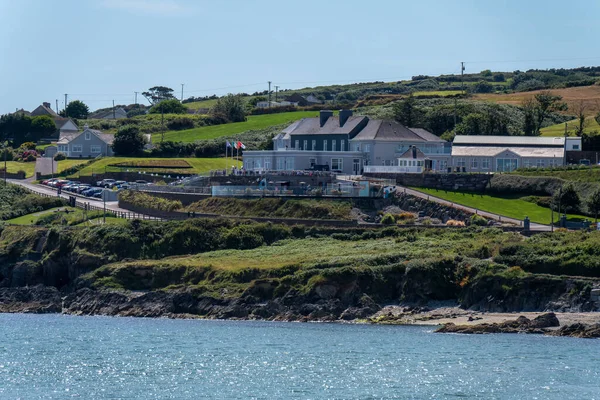 在阳光明媚的夏日 爱尔兰海湾的海岸 爱尔兰的丘陵地带 绿树附近的房子和水体 — 图库照片