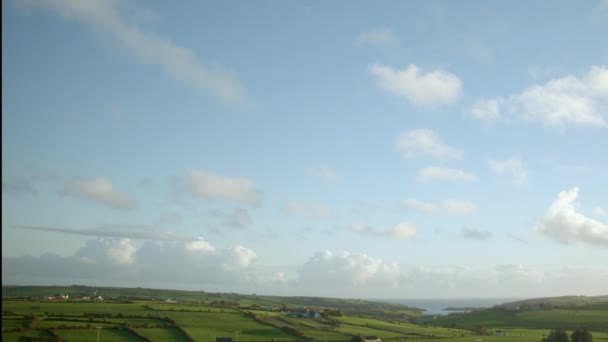 雲はすぐにアイルランドの緑の丘の上の青い空を横切って動いています — ストック動画