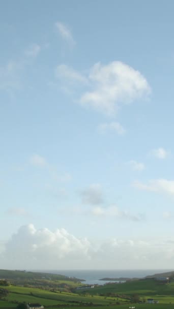 タイムラプスの映像では アイルランドの緑豊かな丘の上の青い空に白い積雲が急速に移動している様子が紹介されています 垂直ビデオ — ストック動画