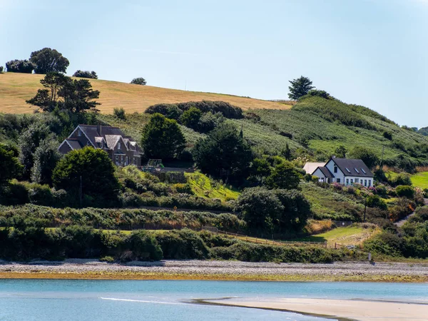 一个阳光明媚的夏日 爱尔兰海湾的海滨 爱尔兰的丘陵地带 绿树附近的房子和水体 — 图库照片