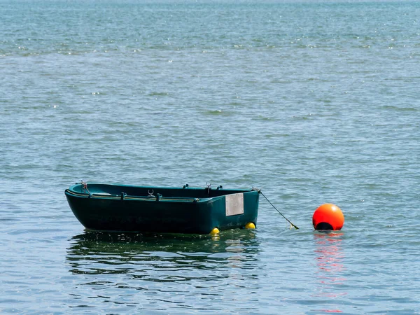 一只单人塑料船在水面上 船边水面上的橙色浮标 船身上的船 — 图库照片