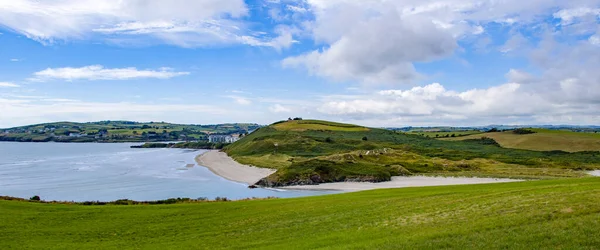 晴れた夏の日には インチドニー島と有名なアイルランドのビーチの緑の丘 アイルランド沿岸の白い雲と澄んだ空 アイルランドの夏の風景 水の近くの緑の草原 — ストック写真