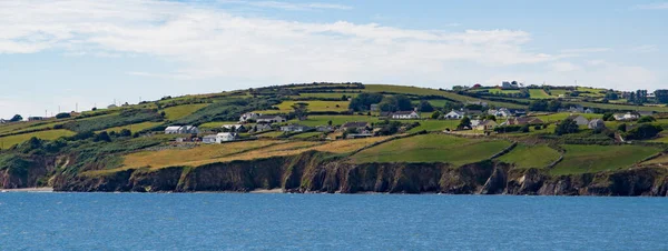 stock image An Irish settlement on the rocky shore of the Atlantic Ocean on a summer day. Seaside landscape, blue sea under blue sky.